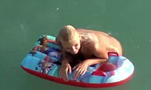 Blondine met bolle kont pronkt met haar bezittingen in het water