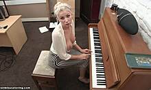 חזה בלונדיני נופל בזמן שהיא מנגנת על הפסנתר במצלמה